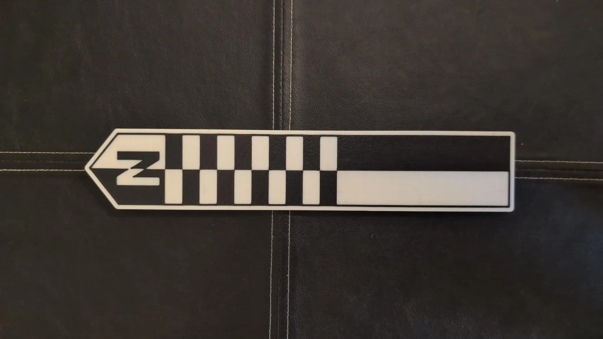 Black and white 3D printed north arrow with a checkered scale bar