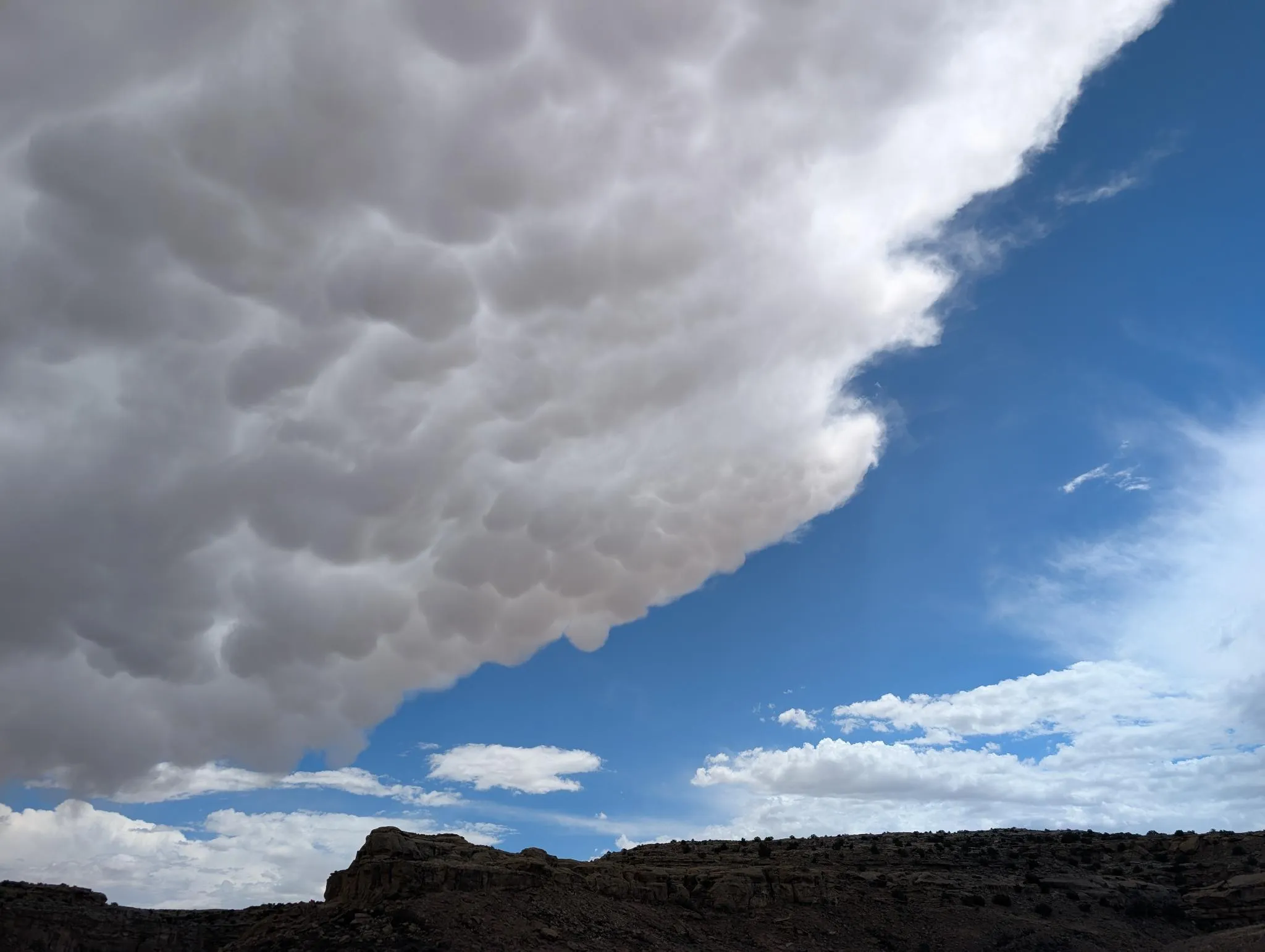 Mammatus storm cloud over a dark mesa rim